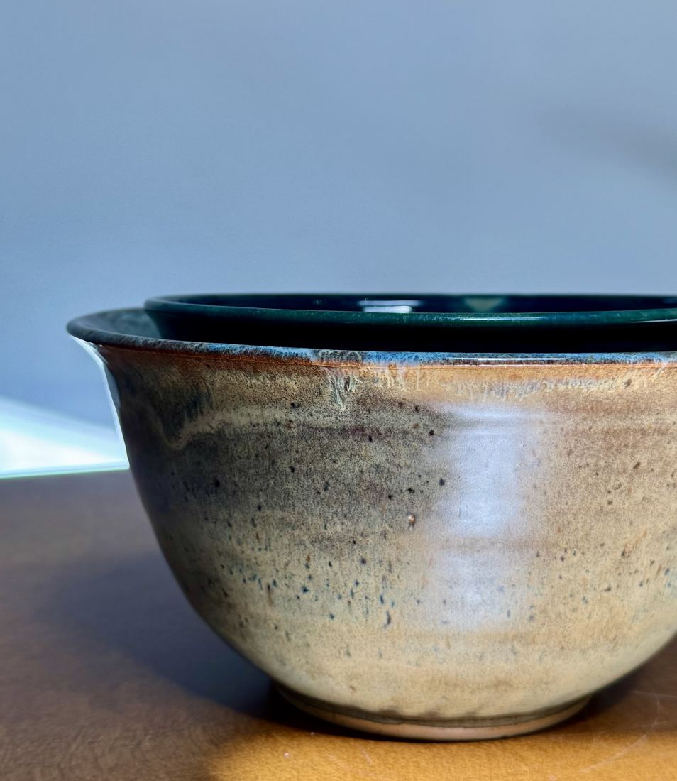 Two nesting bowls, oat outside with deep green interiors