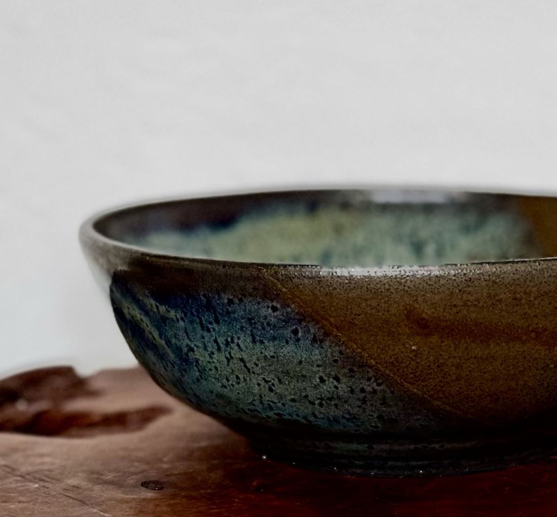 Serving bowl with a blue-green sweep across dark clay