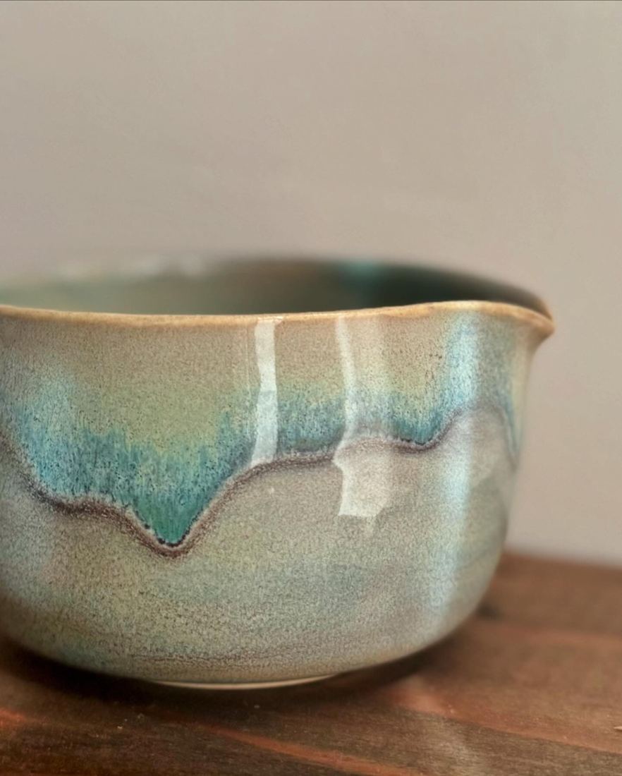 Pouring bowl with a turquoise glaze dripping over sage